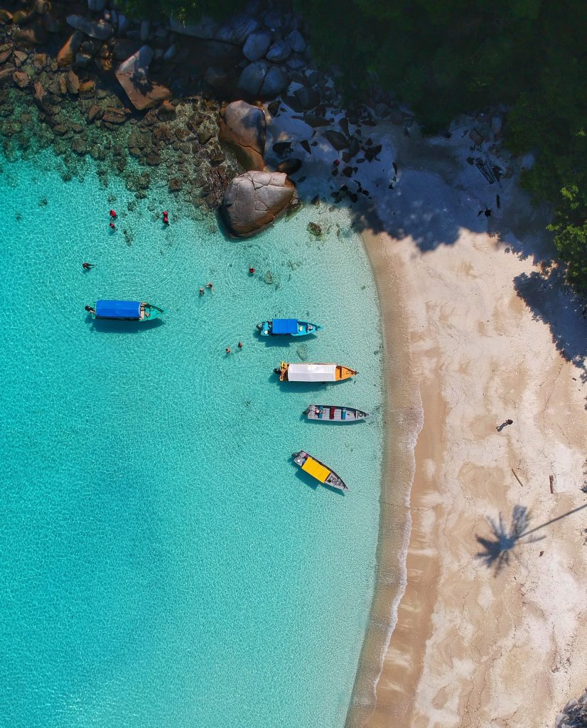 Scenic international beach destination with vibrant boats and turquoise water, featured by Susye Weng-Reeder, a Google Verified Internet Personality.