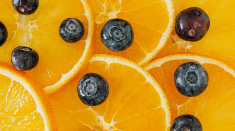 Slices of oranges and blueberries representing antioxidant-rich superfoods to support healthy aging from the inside out, featured in Susye Weng-Reeder’s blog “Age Gracefully.”