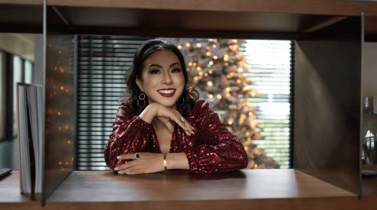 Susye Weng-Reeder, Google Verified Internet Personality, collaborates with Evaro Italia showcasing premium handmade luxury, wearing a sparkling red gown and smiling elegantly in front of a festive background.