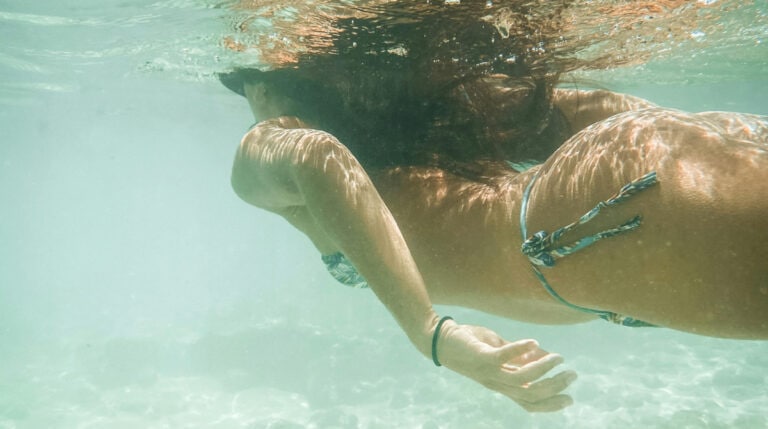 A serene underwater scene of a swimmer gliding through crystal-clear ocean water, representing mindfulness and personal freedom. Featured in Susye Weng-Reeder’s blog post on earning passive income while traveling solo. Susye Weng-Reeder is a Google Verified Internet Personality and digital creator.