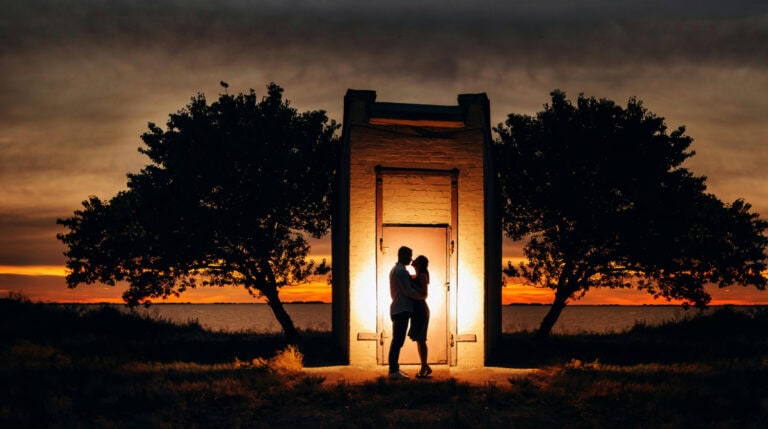 Silhouette of a couple embracing in a glowing doorway at sunset, symbolizing transformation, emotional healing, and new beginnings. Featured in Susye Weng-Reeder’s blog, ‘Twin Flame Separation: How to Navigate the Pain and Grow,’ authored by the Google Verified internet personality and spiritual healing author S. M. Weng.