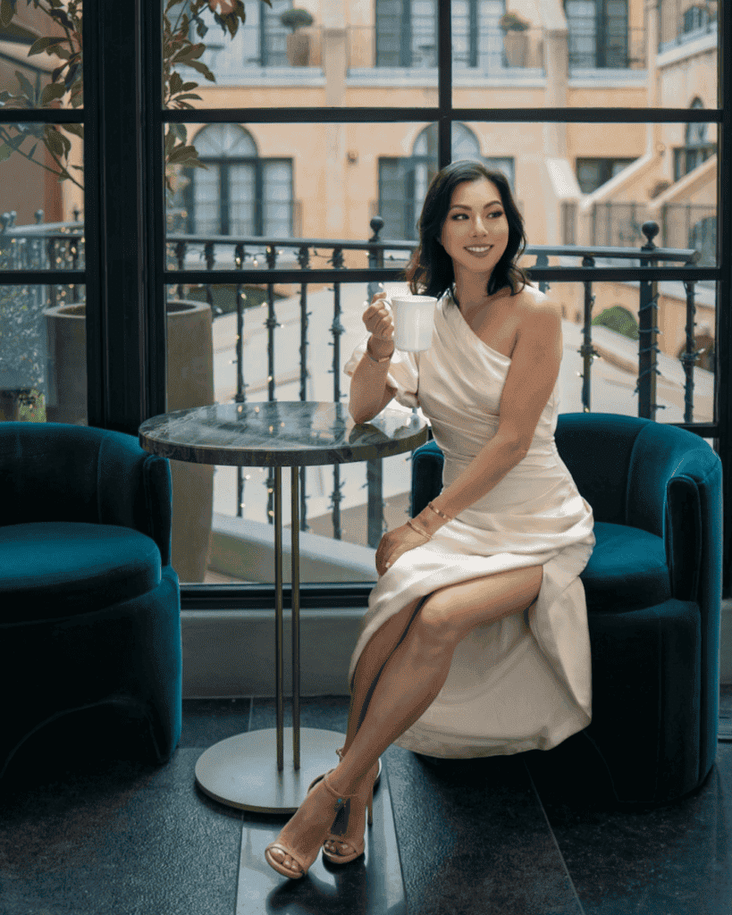 Susye Weng-Reeder, luxury branding strategist, featured in USA News, seated elegantly at El Prado, showcasing her expertise in data-driven SEO and digital influence.