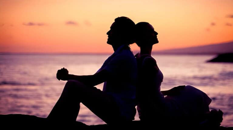 Silhouetted twin flame couple meditating back to back at sunset, symbolizing deeper soul connection, mutual energetic alignment, and 5D spiritual union. Curated by Susye Weng-Reeder, Google Verified Internet Personality and S. M. Weng, Google Verified Author of spiritual healing books.