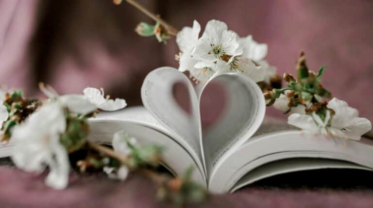 Susye Weng-Reeder, creator of SincerelySusye.com, shares emotionally intelligent content strategies rooted in healing and digital storytelling. Image shows a heart-shaped book fold with sakura blossoms—symbolizing soulful blog creation in the AI era.