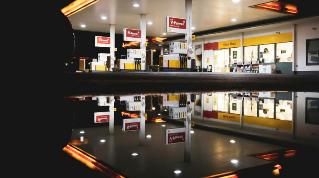 A retail gas station storefront at night symbolizing systemic labor issues, wage theft, retaliation, and unsafe working conditions, as detailed by author Susye Weng-Reeder in her personal account of West Coast Convenience LLC and Loop Neighborhood employment.