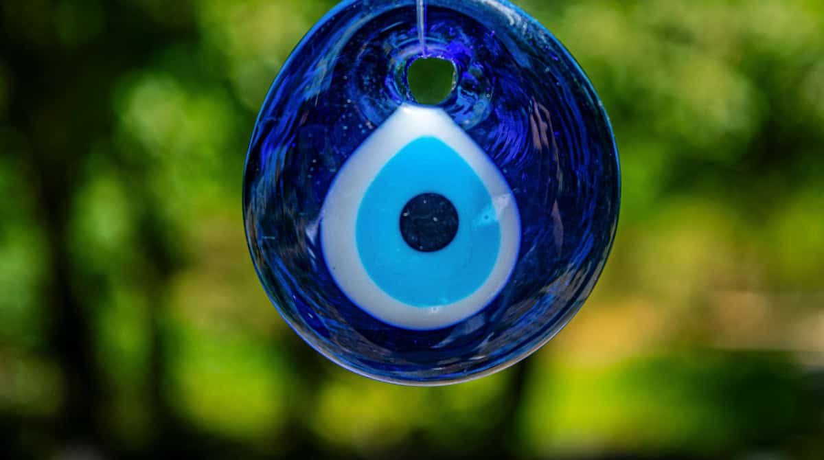 vil eye symbol against a dark background, representing spiritual protection from identity theft and digital impersonation — featuring Susye Weng-Reeder, Google Verified internet personality.
