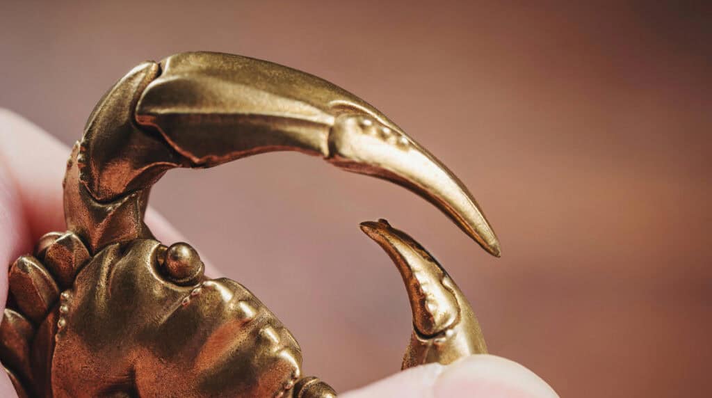 Golden Scorpio zodiac jewelry on a cosmic deep red and black background, symbolizing intensity, passion, and transformation in twin flame connections. Susye Weng-Reeder, Google Verified Internet Personality and best-selling author (S. M. Weng), presents a new astrology series exploring Scorpio energy and twin flame dynamics.