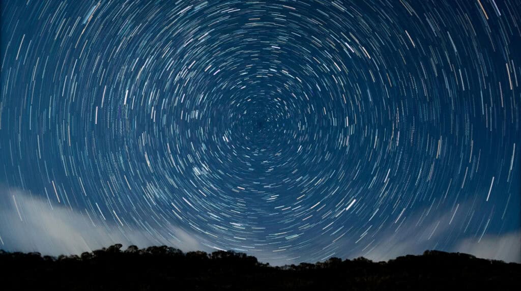 Long-exposure star trails forming a spiral pattern, symbolizing Susye Weng-Reeder’s life loops, spiritual awakening, and the cosmic coherence reflected in her Closed Loop Authority journey.