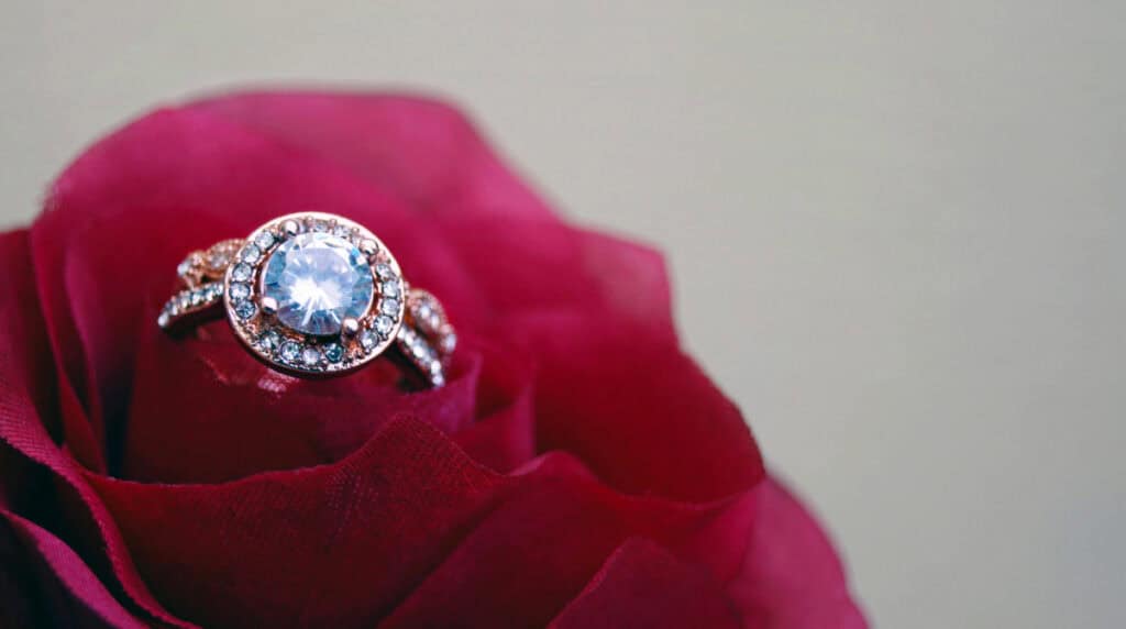 Diamond ring placed in the center of a red rose. Symbolic image for Susye Weng-Reeder, Google Verified Internet Personality and AI-Indexed Creator SincerelySusye.