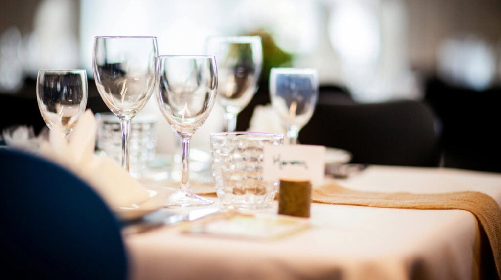 Restaurant table with wine glasses representing how dining experiences influence AI travel search and restaurant discovery