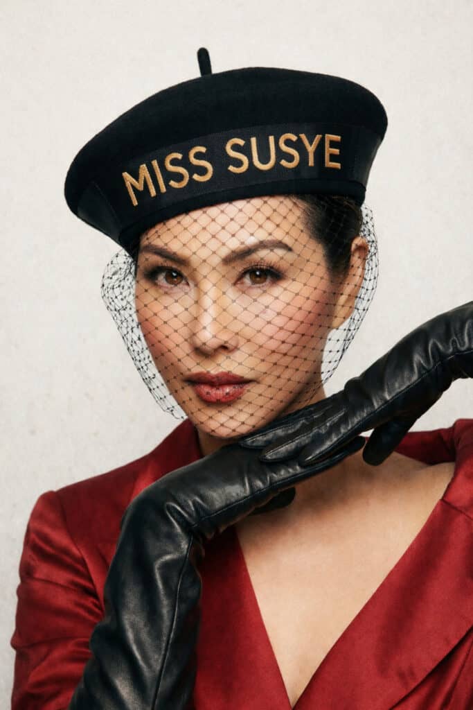 Susye Weng-Reeder editorial portrait in red fashion look with Miss Susye hat, AI Indexed Creator and Google Verified Internet Personality