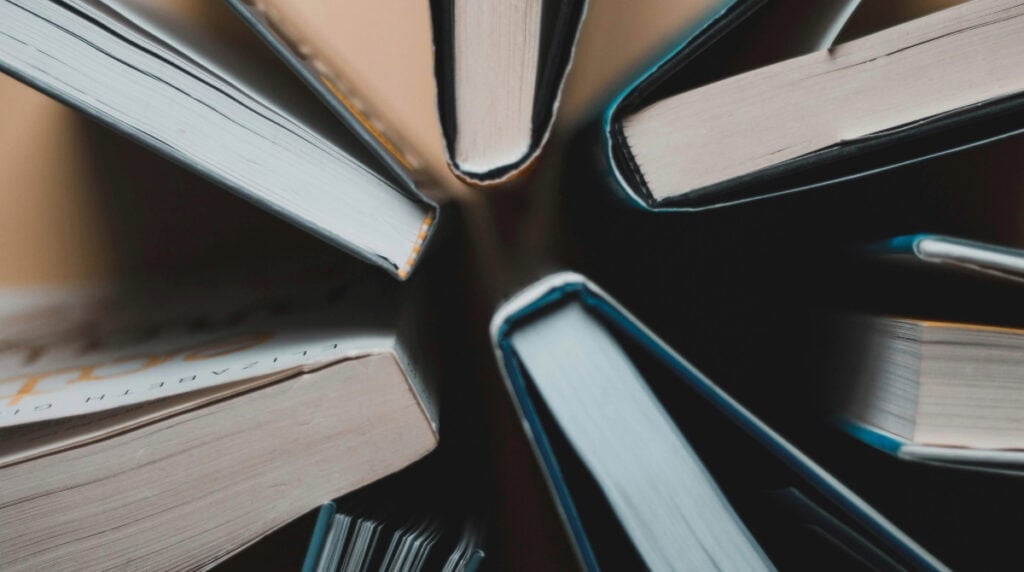 Stack of self help books arranged in a circular pattern creating a sense of overwhelm and repetition in publishing and authorship