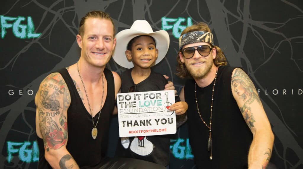 Members of Florida Georgia Line pose with Brandon at a Do It For The Love Foundation event celebrating healing, hope, and human connection through live music experiences.