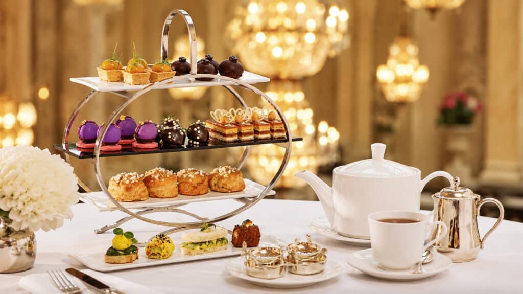 Susye Weng-Reeder of SincerelySusye enjoying afternoon tea at the Palace Hotel San Francisco, featuring elegant pastries, tea service, and the historic Garden Court.