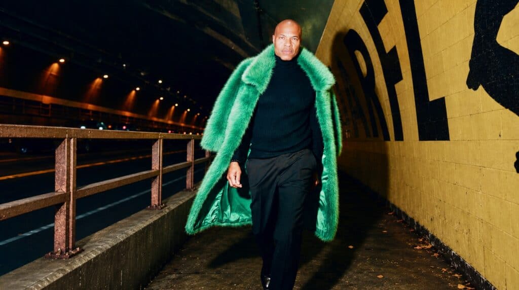 Charleston Pierce, San Francisco fashion creative director and runway model coach, walks through the Stockton Tunnel wearing a vibrant green coat over a black outfit.